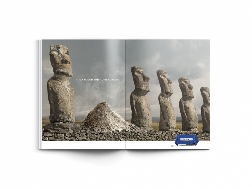 Image of a print advertisement mockup that shows the Easter Island statues with one turned to dust.