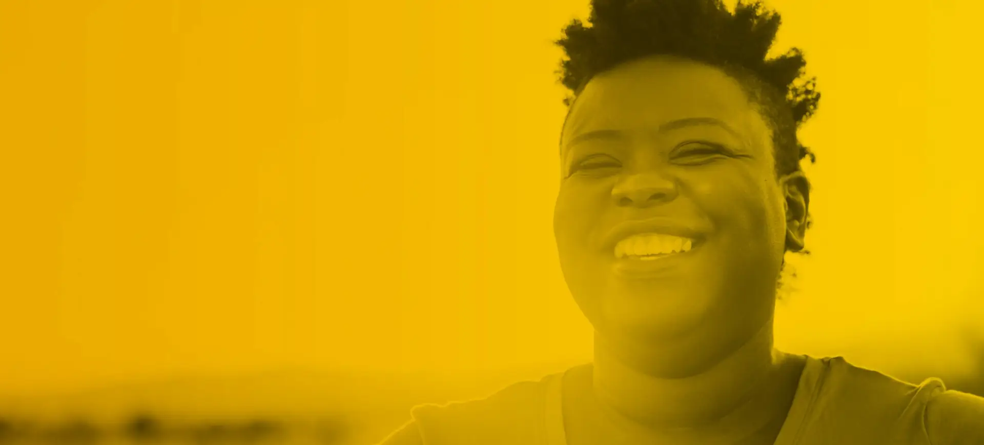 Image of a woman smiling with a yellow overlay to communicate happiness.