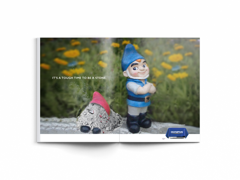 Image of a print advertisement mockup that shows two gnome statues with one turned to dust.